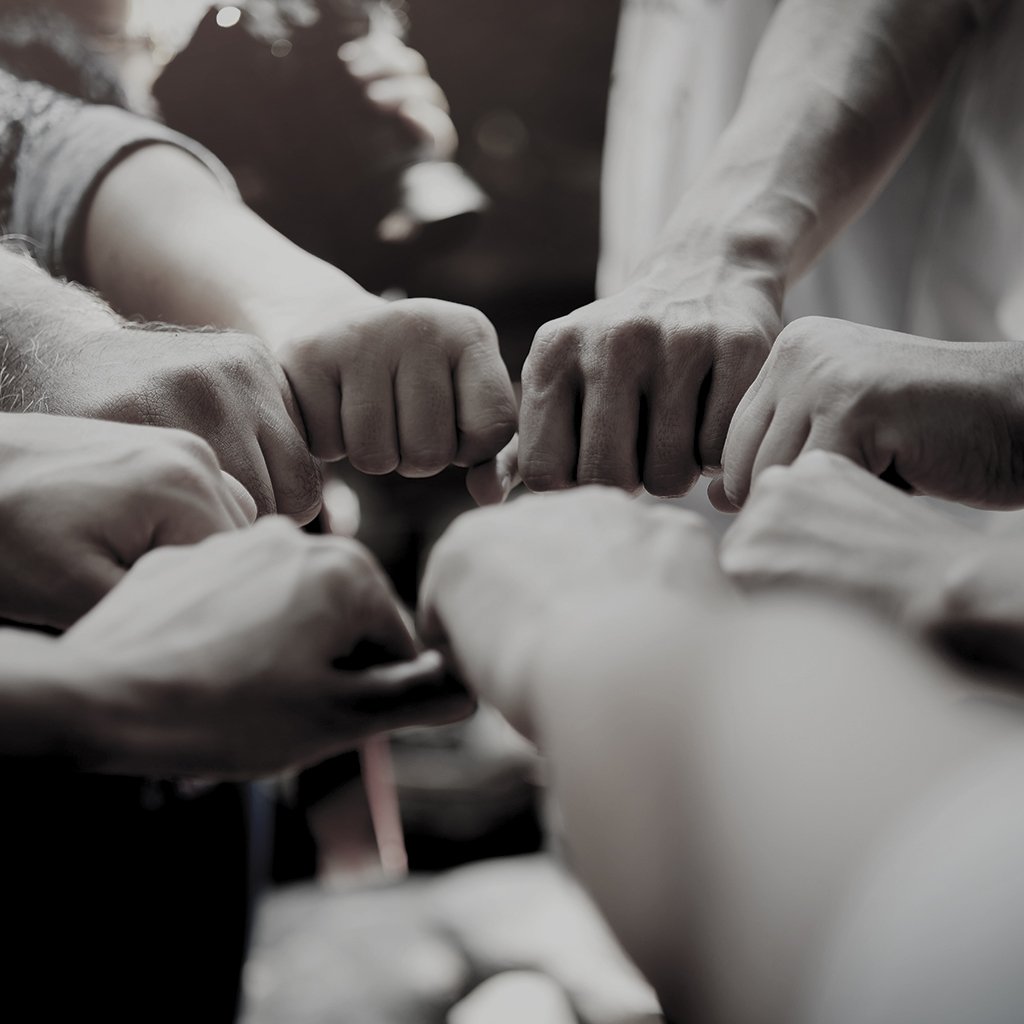Grupo de pessoas tocando os punhos em sinal de união